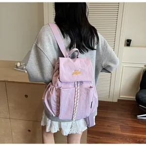 Dettaglio dello zaino in nylon lavanda con ricamo giallo e chiusura a coulisse pratica