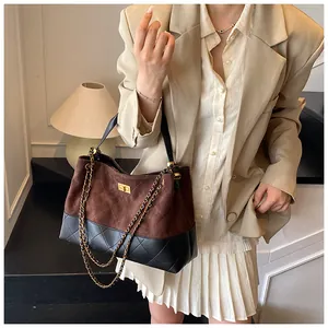 Détail du sac seau bicolore avec cuir noir matelassé et fermoir rotatif doré