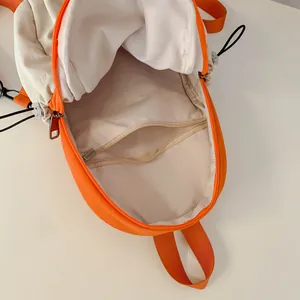 Minimalist ivory and orange nylon backpack showing interior compartment and zipper pocket