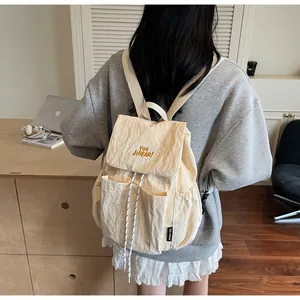 Dettaglio dello zaino crema con ricamo YOU JI BEAR e tasche laterali per uso quotidiano