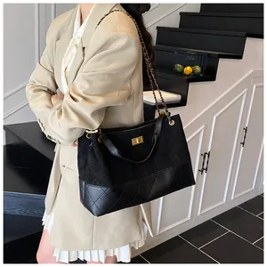 Détail du sac seau noir matelassé avec bandoulière chaîne dorée et fermoir métallique chic