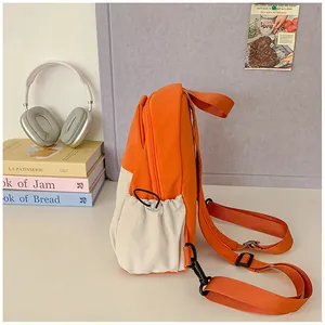 Detail of canvas backpack featuring orange side pockets with adjustable drawstrings