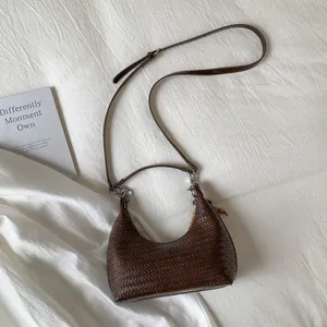 Close-up of deep brown woven leather hobo bag with adjustable strap and silver hardware
