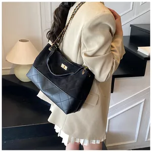 Détail d'un sac seau rétro en cuir matelassé avec bandoulière en chaîne dorée