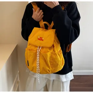 Dettagli dello zaino in nylon giallo brillante con chiusura a coulisse e scritte rosse
