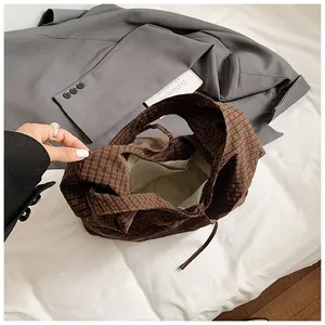 Brown checkered canvas tote bag with bow tie design and large interior storage space