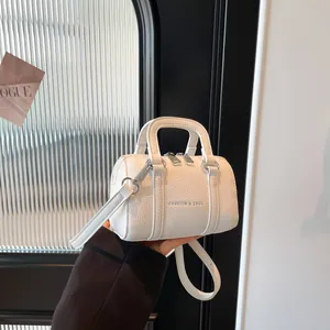 Stylish white leather Boston handbag with litchi texture and detachable crossbody strap
