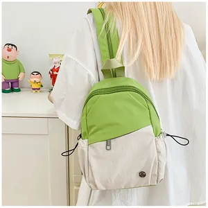 Detail view of the drawstring side pocket on the green and cream patchwork backpack