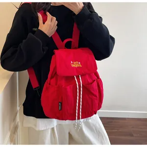 Dettaglio dello zaino in nylon rosso con ricamo giallo e chiusura con coulisse bianca