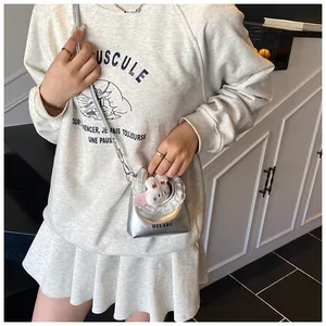 Detailaufnahme der silbernen Mini-Cloud-Tasche mit Spitzenbesatz und Plüschanhänger