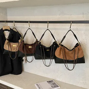 Sacs seaux chic bicolores avec texture matelassée et bandoulières chaîne en quatre tons