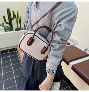 Close-up of beige canvas and brown leather bowling bag with adjustable shoulder strap