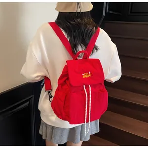 Vista posteriore dello zaino in nylon rosso con coulisse indossato da una modella reale