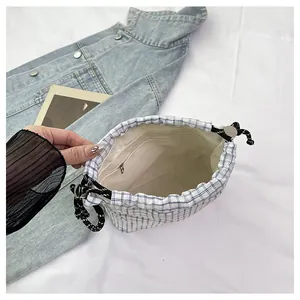 Detail view of the blue checkered tote bag interior with a secure metal zipper pocket