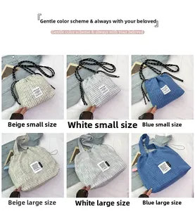 Detail of plaid canvas tote bags showing texture, drawstring closure and woven label