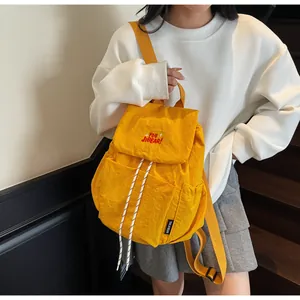 Dettaglio di uno zaino in nylon giallo con coulisse e ricamo rosso YOU JIBEAR