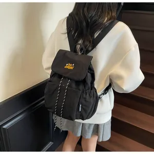Dettaglio del ricamo giallo YOU JIBEAR su uno zaino nero in nylon con coulisse regolabile