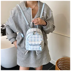 Mini blue and white checkered backpack shown as a stylish crossbody bag on a model