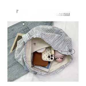 Blue plaid canvas drawstring tote interior showing compartments for iPad and wallet