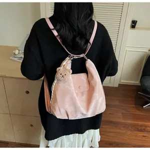 Pink soft leather backpack featuring a plush bear charm and decorative striped silk scarf