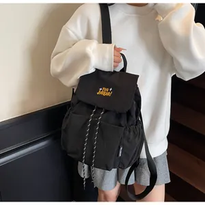 Dettaglio dello zaino in nylon con coulisse e ricamo giallo sulla patta sul modello