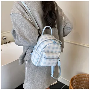 Close-up of mini blue gingham backpack with silver zippers and adjustable straps