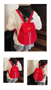 Dettaglio dello zaino rosso in nylon con coulisse e ricamo JIBEAR giallo