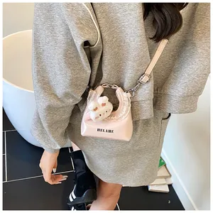 Detail der rosa Mini-Cloud-Tasche mit Spitzenbesatz, Kaninchenanhänger und Logo