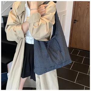 Detail of blue and grey checkered tote bag featuring a decorative side bow drawstring