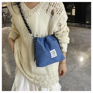 Detail of blue checkered tote bag with drawstring closure and stylish fabric texture