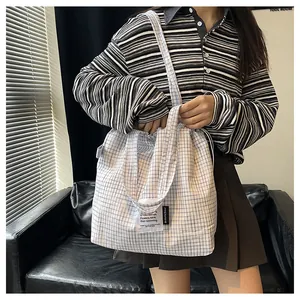 Close-up of blue and white checkered tote bag with ArtisticSoul label and drawstring detail