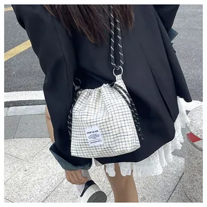 Detail view of blue and white checkered drawstring tote bag with thick woven rope strap