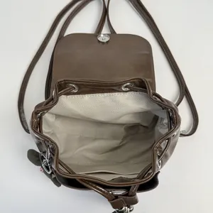 Vintage brown PU leather backpack for women with drawstring closure and green plush charm