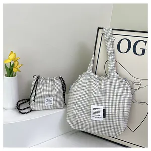 Close-up of blue checkered tote bag set with detailed fabric texture and logo patch