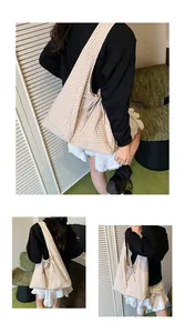 Detailed close-up showing the elegant bow decoration and texture of the checkered tote bag