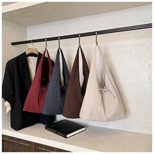 Detailed close-up of four plaid bow shoulder bags in red, blue, coffee and cream