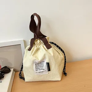 Bolsa de almuerzo aislada beige con cordón y asas marrones para el viaje diario al trabajo