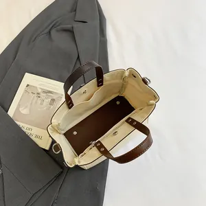 Bolso tote de lona con asas de cuero marrón oscuro e interior espacioso visto desde arriba