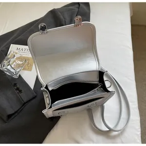 Detail view of the silver metallic crossbody bag showing internal zipper pocket