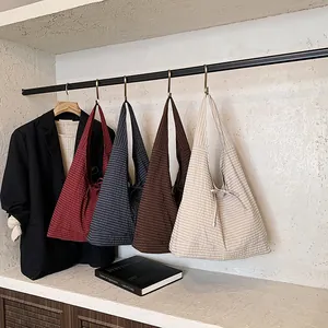 Gingham bow tie tote bags in red, blue, brown, and beige hanging for fashion display