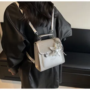 Silver glitter backpack detail with star charm and metallic texture on a model