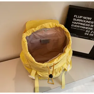 Vue détaillée du sac à dos jaune avec fermeture à cordon et poche intérieure zippée