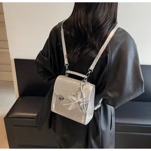 Silver sequin backpack with metallic star charm shown on model in a stylish back view