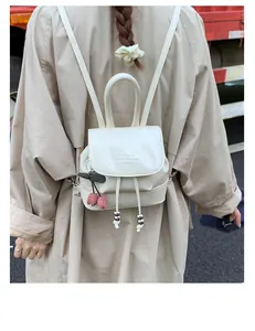 Detail of cream PU leather mini backpack with cherry charm and drawstring closure