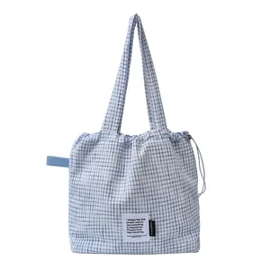 Blue and white checkered drawstring tote bag with rustic quote patch and long straps