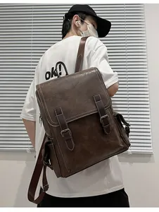 Detail view of a vintage dark brown leather backpack on model with flap and buckle design