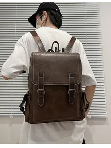 Detail view of dark brown vintage leather backpack with buckled straps and white stitching