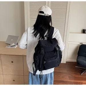 Détail d'un sac à dos noir en nylon avec fermeture à boucle et multiples poches