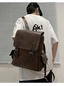 Rear view of model wearing a vintage brown faux leather backpack with contrast stitching