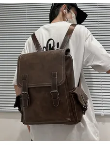Detail view of deep brown vintage backpack with leather texture and white stitching details